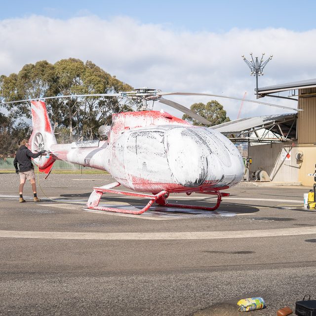 Helicopter covered in snow foam on the helipad